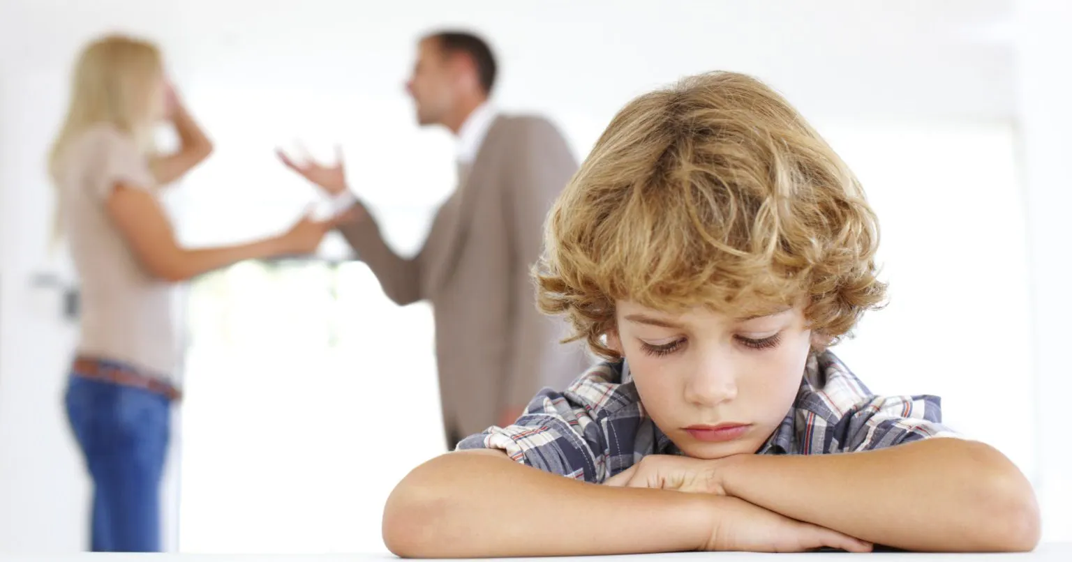 Child in the foreground while two adults argue
