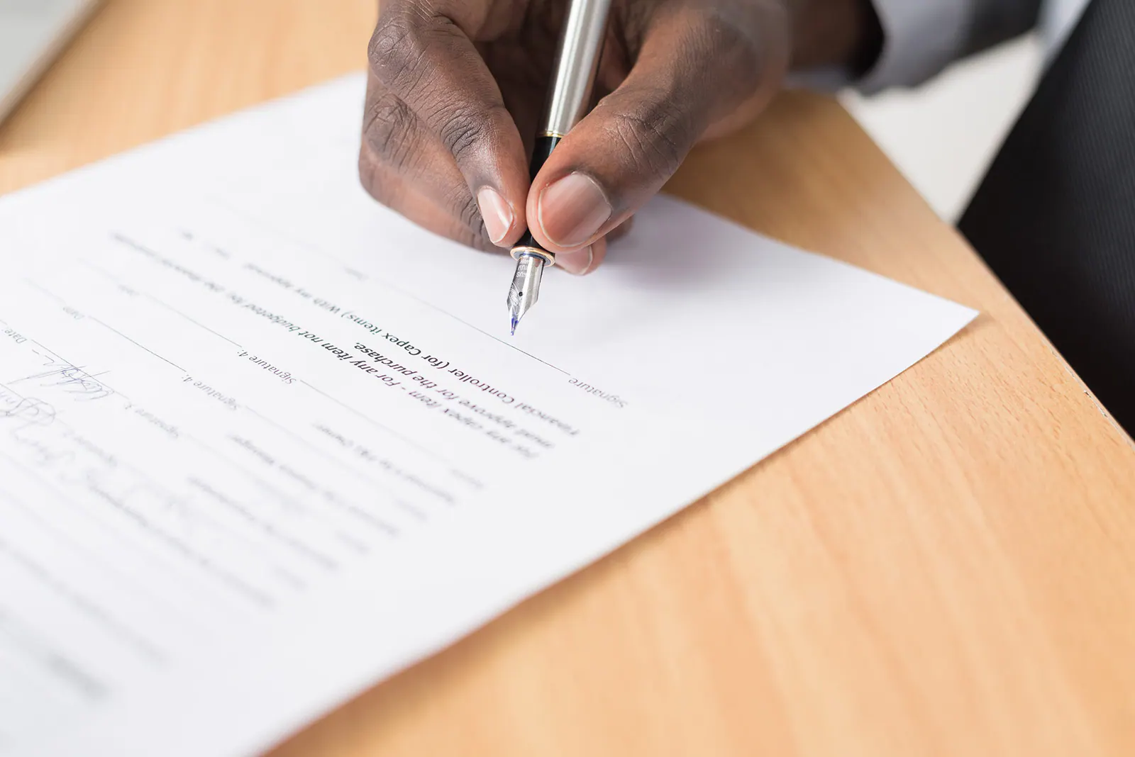Person reviewing and signing estate documents at a desk