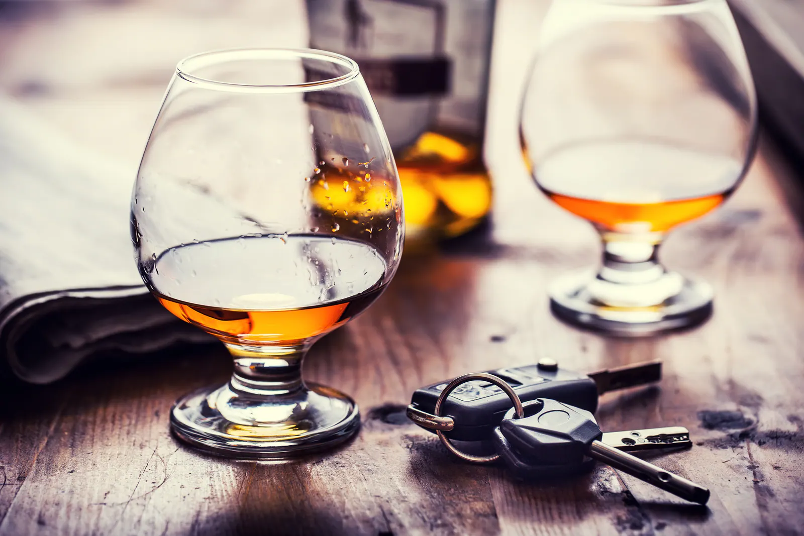 Whiskey glasses beside a car key