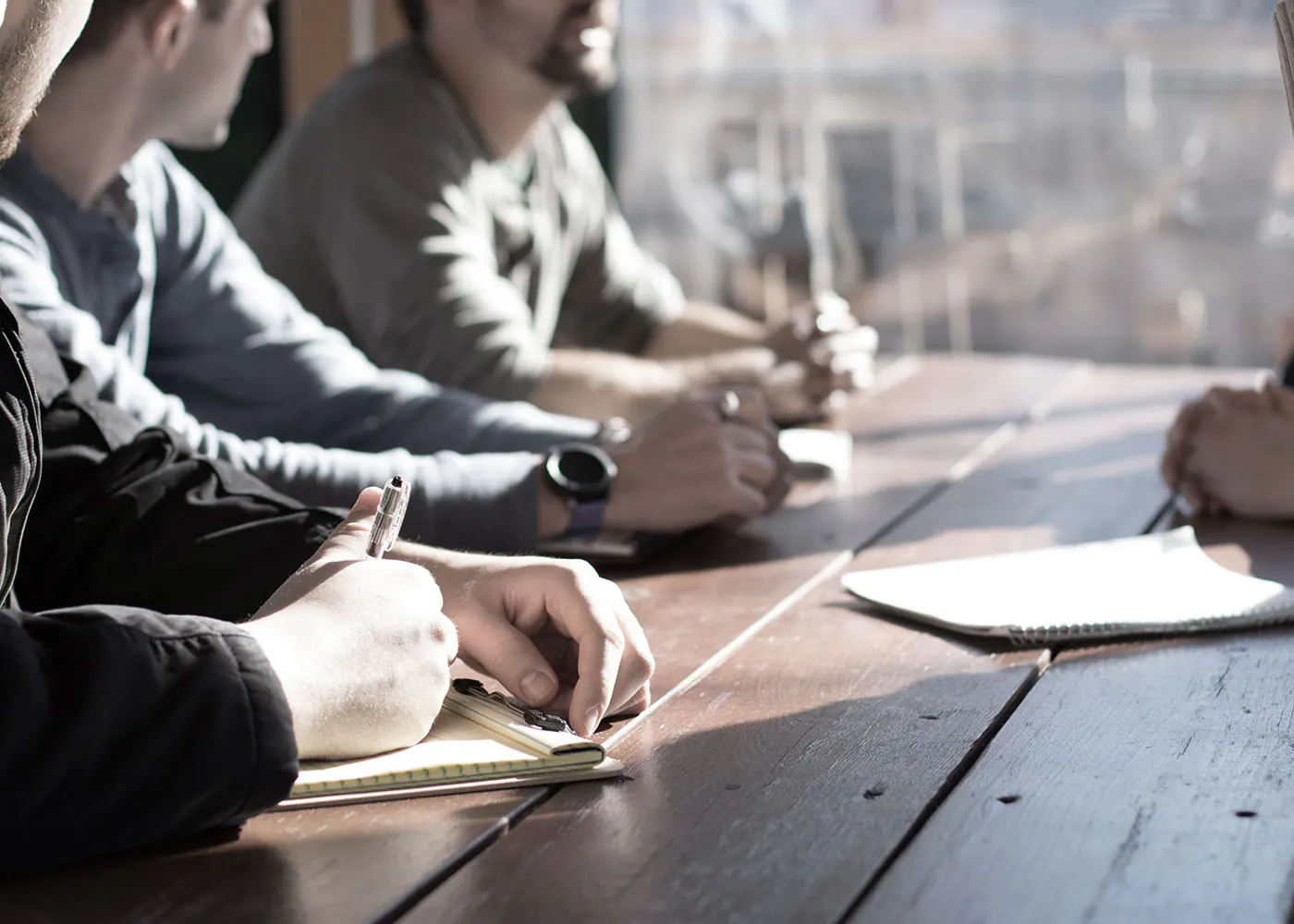 People taking notes during a business meeting