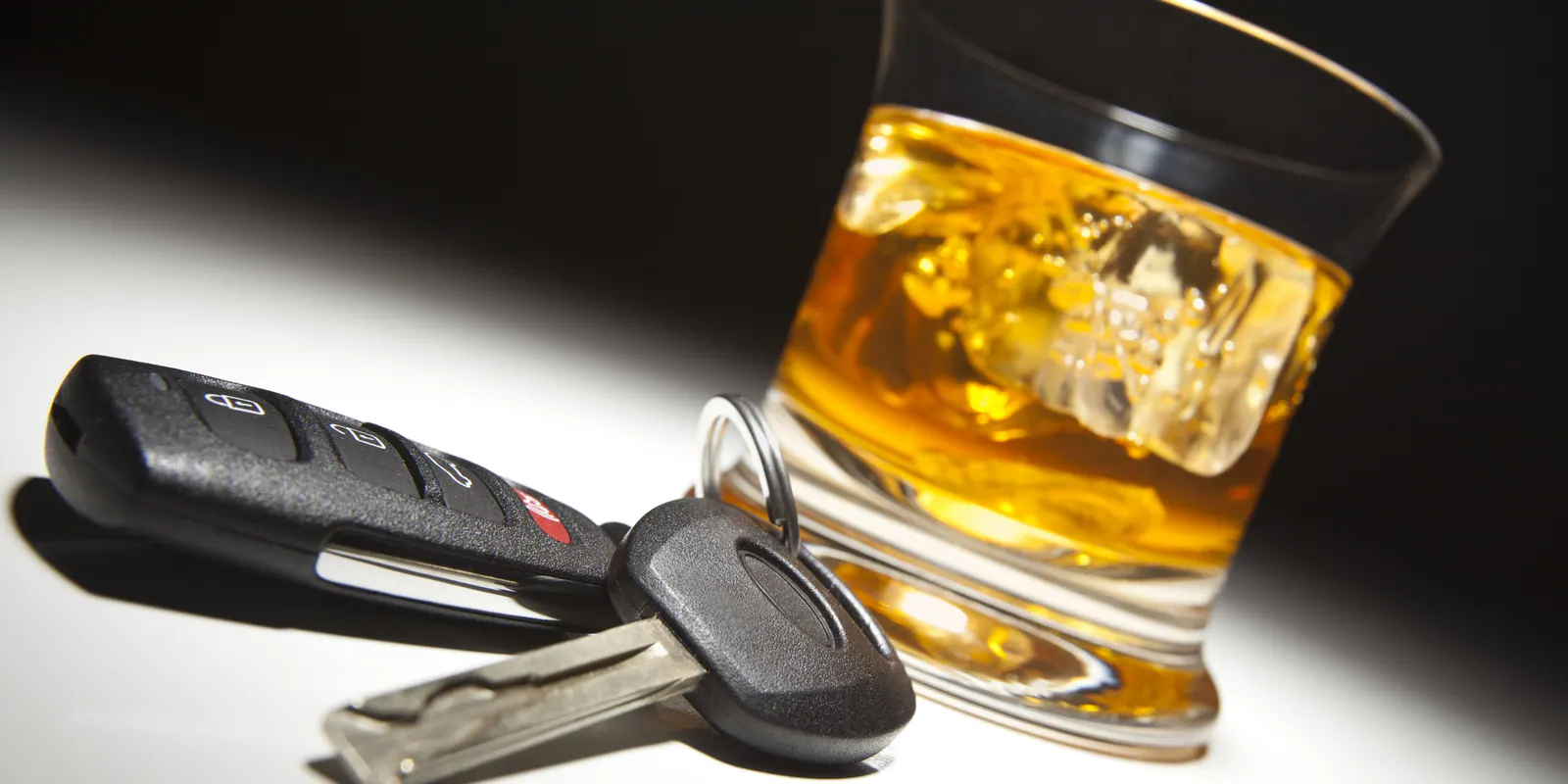 Whiskey glass beside car keys