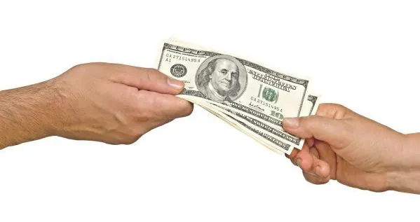 One person handing cash to another